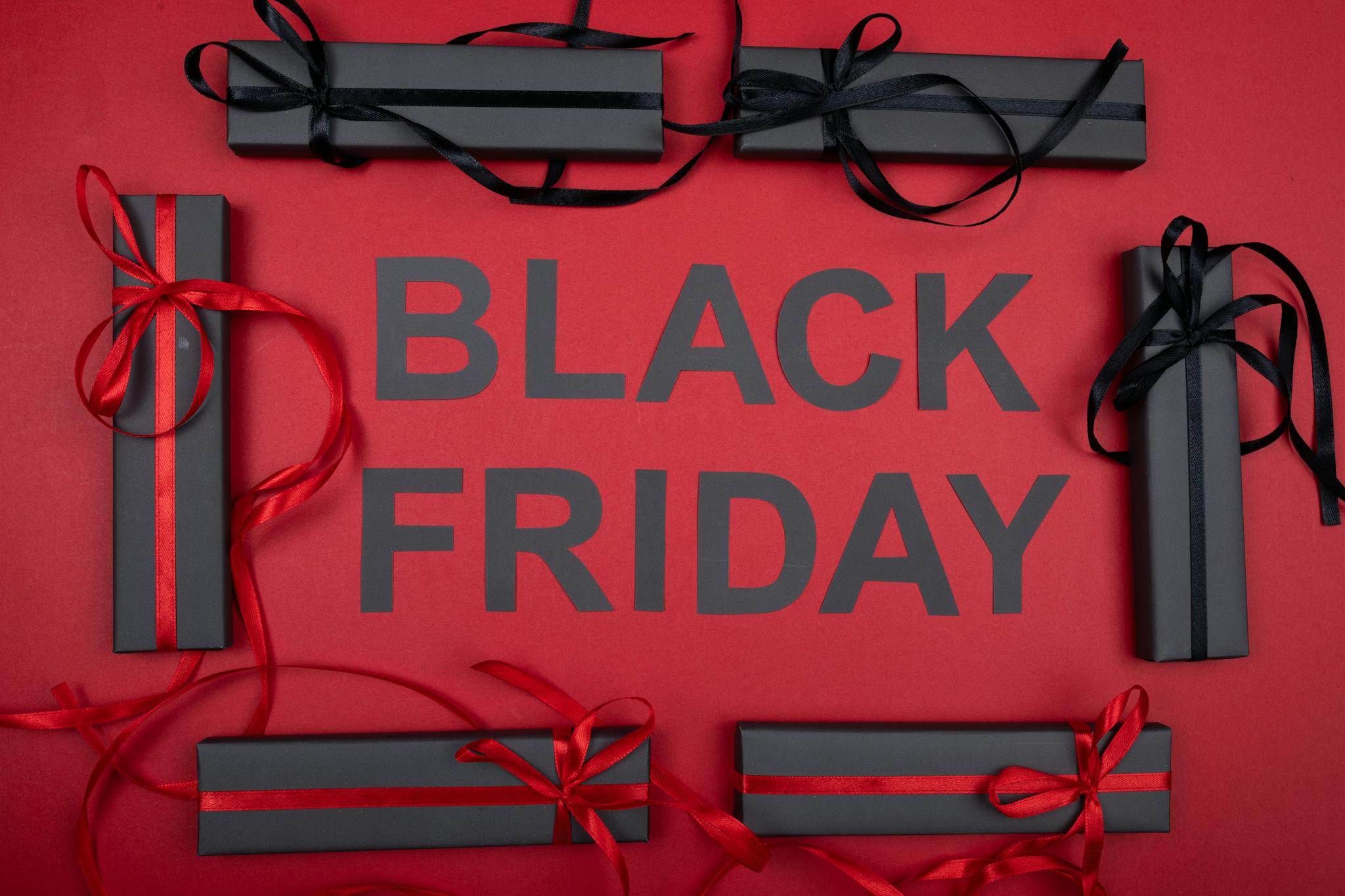 Black Friday themed image with gift boxes and ribbons on a red background.